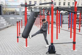The teenager trains on the street exercise machine in the territory of the Open sports space of NSC "Olympic"