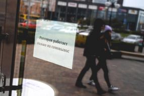 A sign reading "Restaurant only works for self-delivery" behind the restaurant window