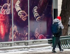 The guy walks on a snowy sidewalk