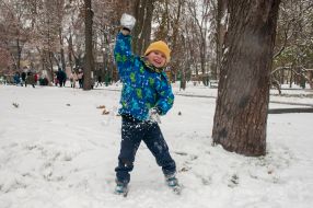 The boy is playing snowballs