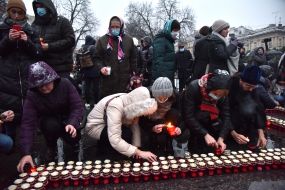 Люди выкладывают лампадки в форме креста
