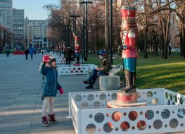 Girl near the sculpture of a tin soldier