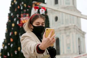 Girl takes a selfie on the background of the Christmas tree