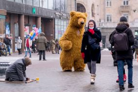 Animator in a bear costume and an elderly woman