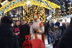 An animator in a costume of St. Nicholas distributes gifts