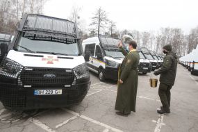 Priest sprinkles holy water on cars