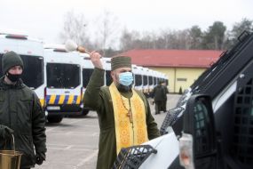 Priest sprinkles holy water on cars