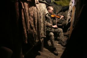 Ukrainian Marine plays the violin in a dugout at a position near occupied Horlivka