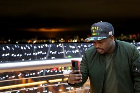 Чоловік фотографує на мобільний телефон на пішохідно-велосипедному мосту