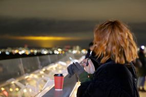 Люди дивляться на заграву на пішохідно-велосипедному мосту