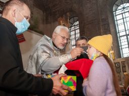 The priest gives communion to the parishioners