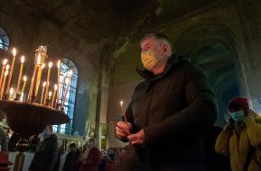 The parishioner lights a candle