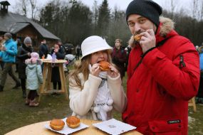 Guests of the holiday "Christmas in the grove" eat donuts