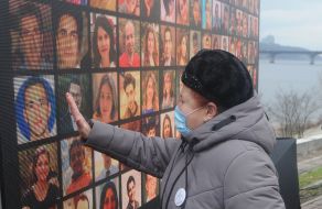 Woman near the wall with photos of dead passengers and crew of UIA flight PS752 in the sky over Tehran