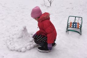 Girl sculpts snowballs