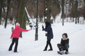 Женщина с девочкой играют в снежки