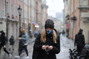 A woman in a medical mask walks down the street