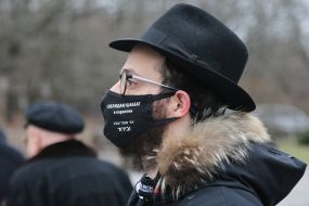 A man in a protective mask with the inscription "Observes the Sabbath and quarantine"