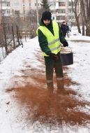 A utility worker sprinkles the track with coffee grounds