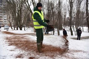 A utility worker sprinkles the track with coffee grounds
