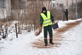 A utility worker sprinkles the track with coffee grounds