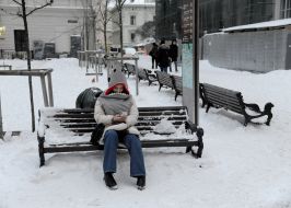 Woman sitting on a snow-covered bench