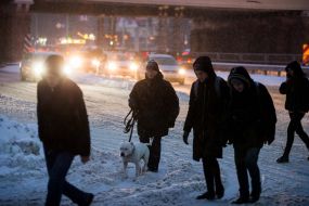 Passers-by cross the snowy road