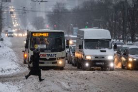 Passers-by cross the snowy road