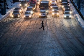 Passers-by cross the snowy road