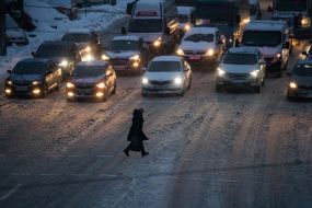 Passers-by cross the snowy road