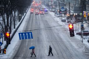 Passers-by cross the snowy road