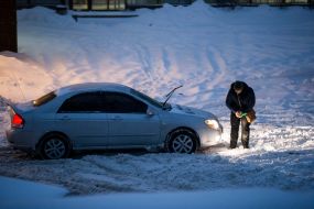 Man cleans the car from snow