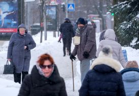A man asks for alms on a snowy street