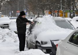 Man cleans the car from snow
