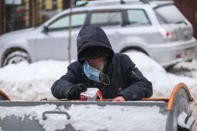 A man rummages in a dumpster