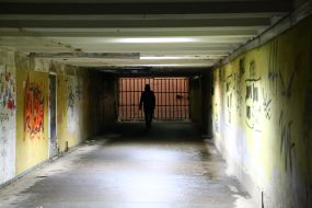 A man walks through the arch of a building