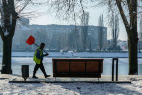 A utility worker with a shovel on his shoulder
