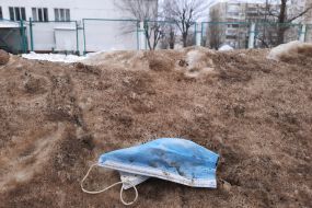 Dirty medical mask lying on the snow