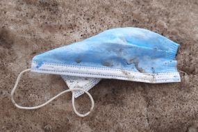 Dirty medical mask lying on the snow
