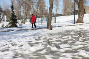 Лужи на снегу во время оттепели в парке в Киеве