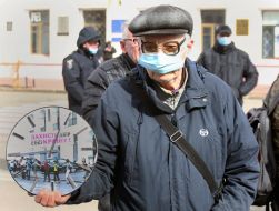 Мужчина держит часы с надписью "Защити двор"