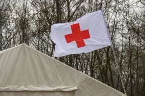 White flag with a red cross near the tent