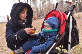 Woman feeds a child with pancakes
