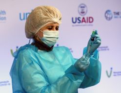 Врач мобильной бригады набирает в шприц вакцину Covishield