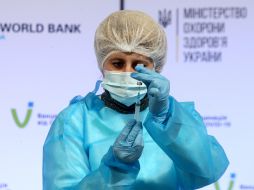 Врач мобильной бригады набирает в шприц вакцину Covishield