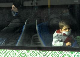 Boy wearing a respiratory mask on public transport in Kiev