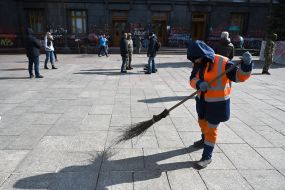 Работница коммунальной службы убирает на площади у здания Офиса президента