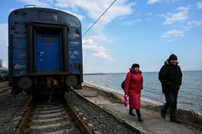 People walk along the railway tracks in Mariupol