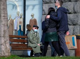 A young couple walks past a man