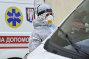 Медпрацівник біля автомобіля швидкої допомоги